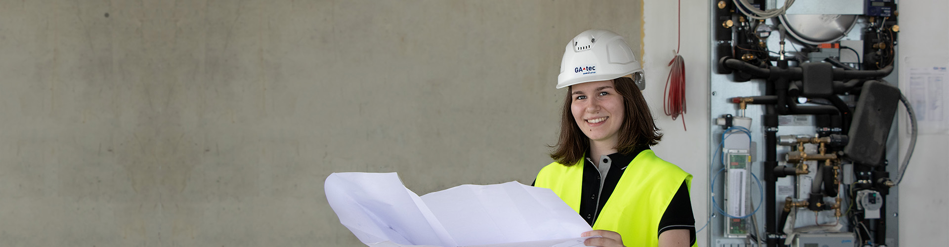 Foto: Mitarbeiterin Anna im Portrait mit einem Plan in der Hand
